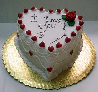 white heart shaped cake with red hearts and draped trimming