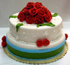 a gorgeous green and white cake with fondant icing and red roses